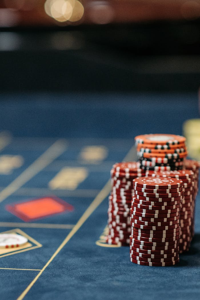 Vertical shot of red poker chips stacked neatly on a casino gaming table, symbolizing gambling and betting.