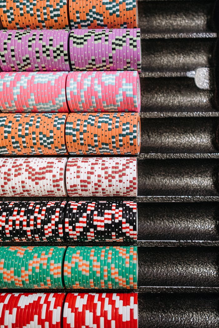 Organized rows of colorful poker chips neatly arranged in a casino tray.